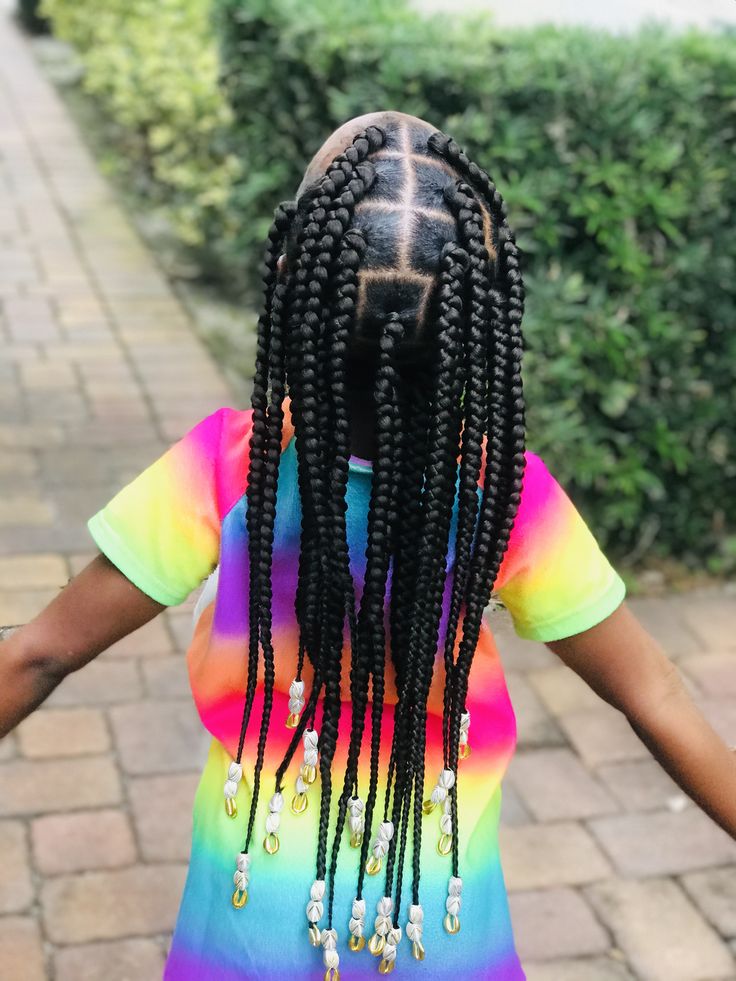 Active child wearing large box braids decorated with beads