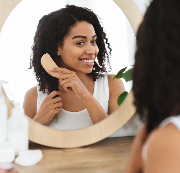 Woman caring for long natural 4C hair as part of a fall routine