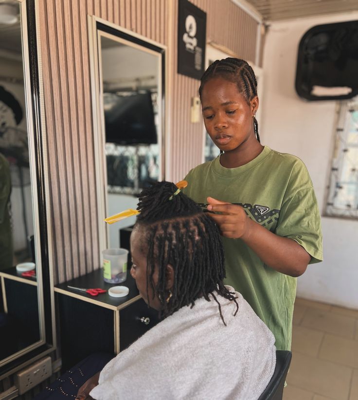 Natural hair professional maintaining new growth on small locs