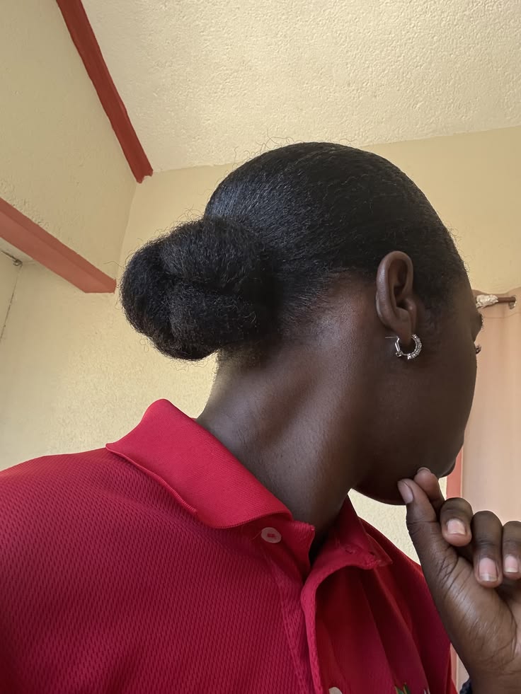 Woman with a neat low braided bun on natural hair