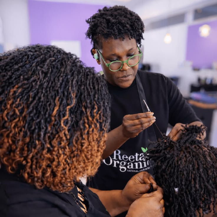 Loctician installing small microlocs using a professional technique