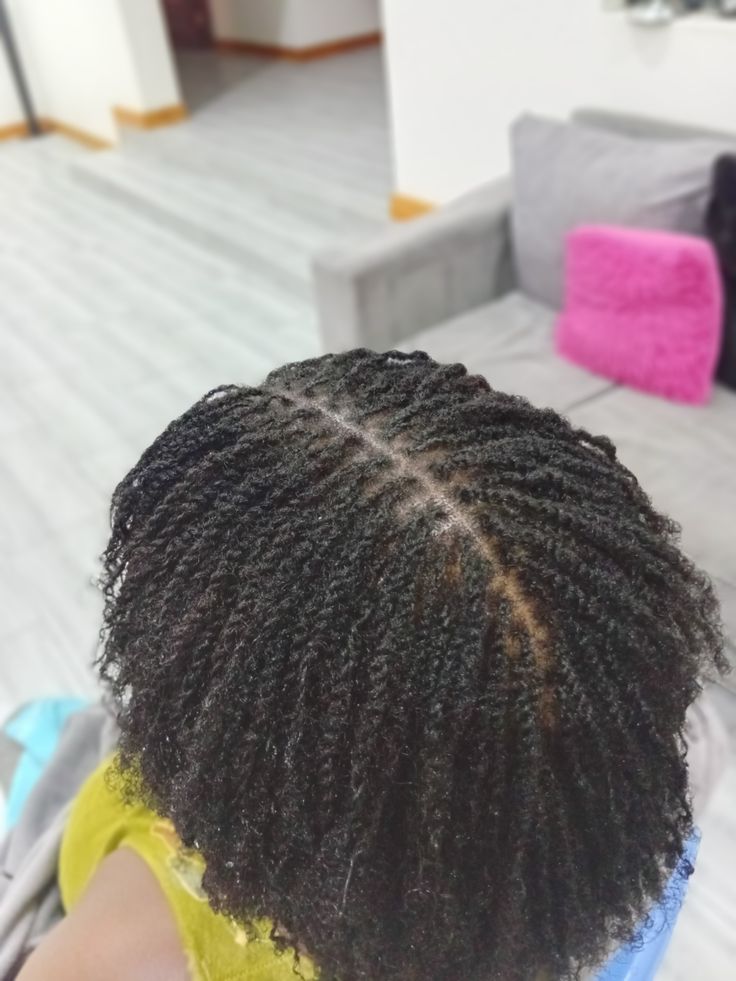 Close-up of small microlocs on tightly coiled natural hair
