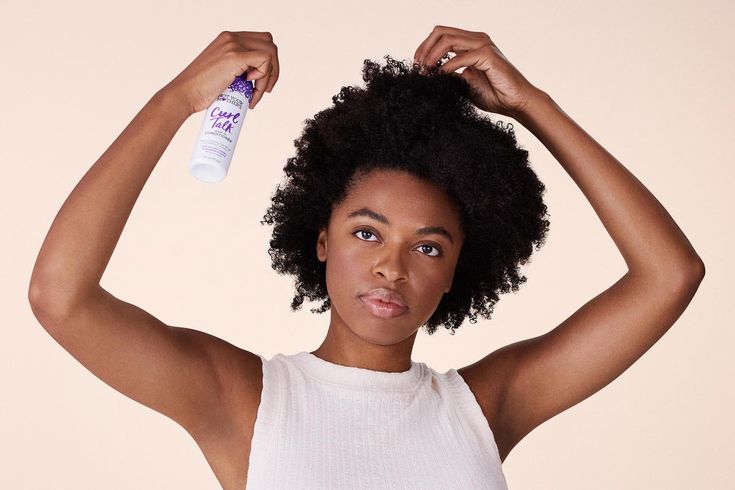 Woman moisturizing her natural 4C hair during summer