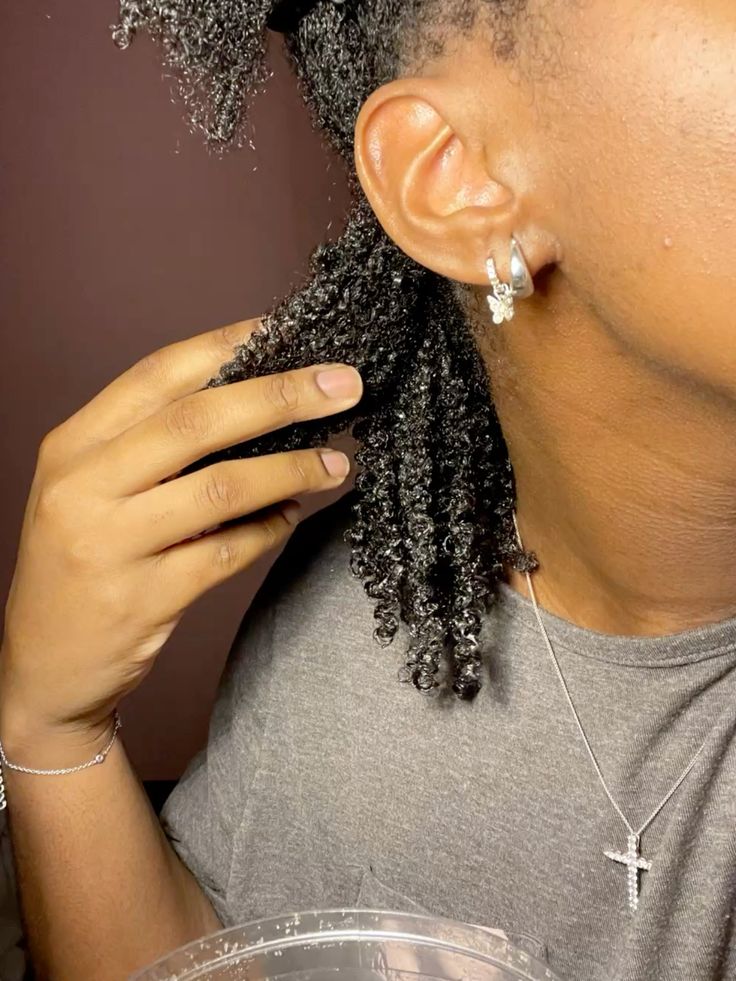 Woman moisturizing freshly washed 4C hair before styling