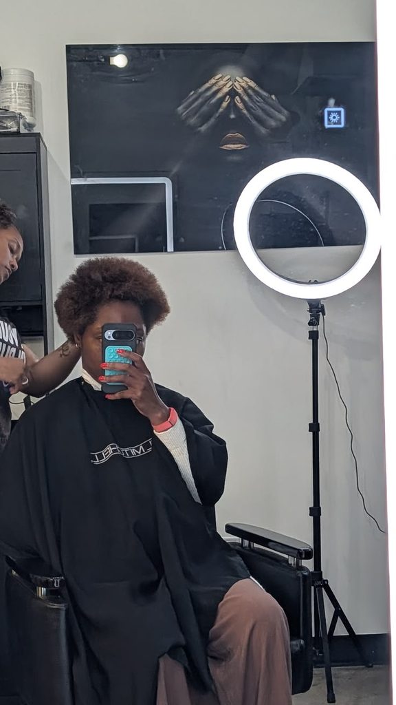 Loctician assessing natural hair density before installing small locs