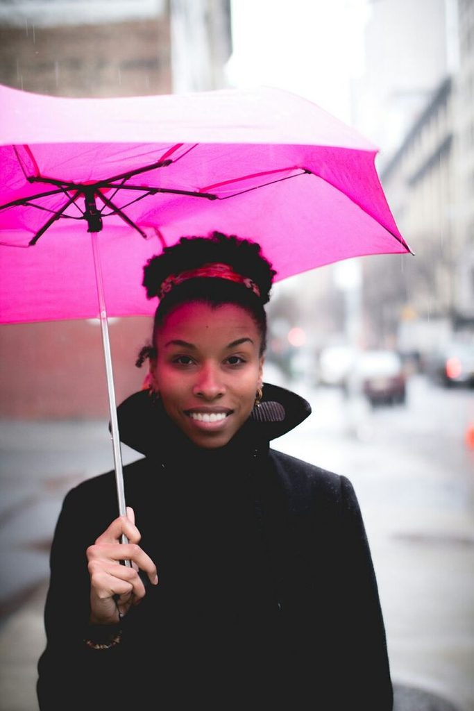 Woman protecting natural 4C hair from summer rain