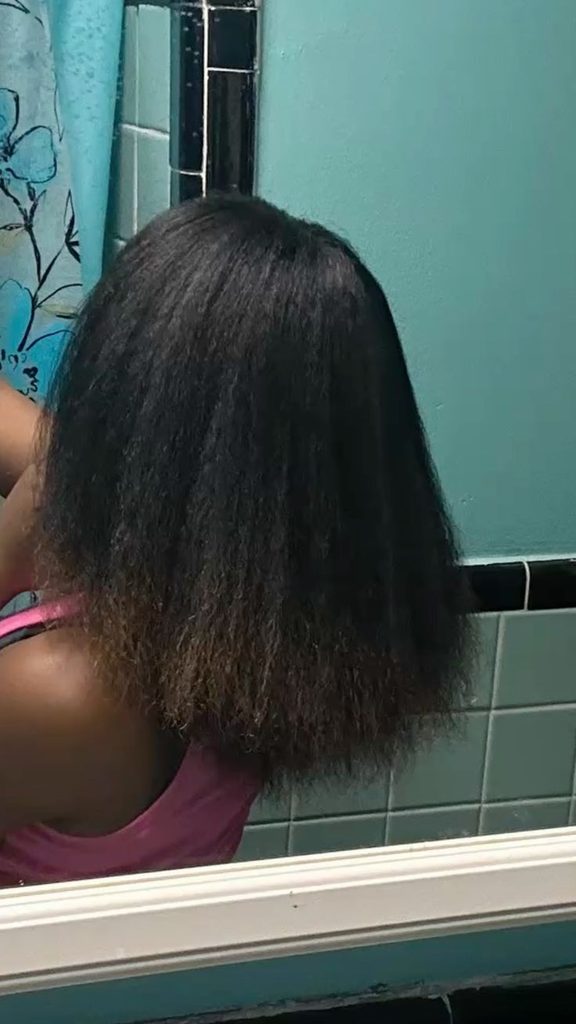 Woman beginning her journey from relaxed hair to natural hai
