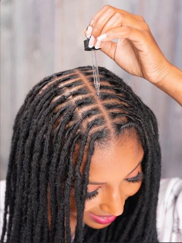 Small amount of oil being applied to a loc-care routine