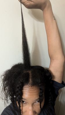Woman showing natural hair growth after one year of transitioning