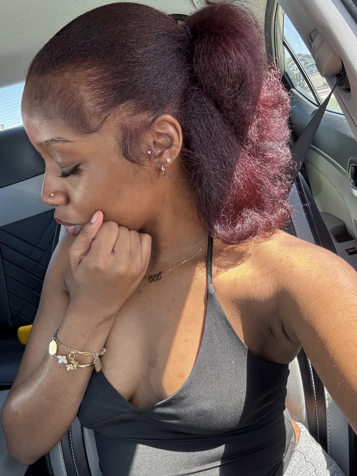 Black woman wearing plum natural hair color for dark skin