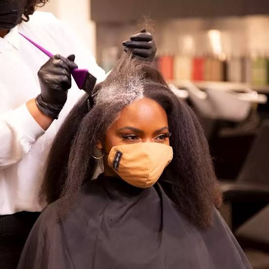 A woman getting her hair bleached bya professional