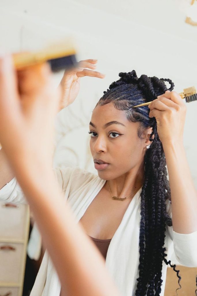 Woman gently styling the edges of natural 4C hair