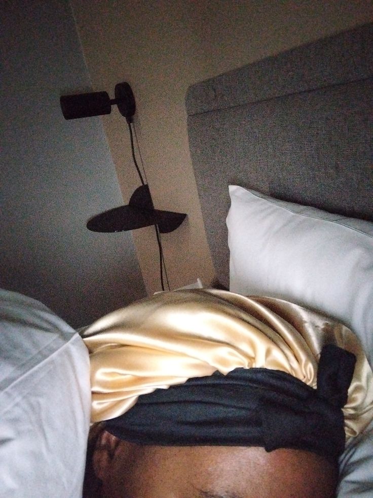 Woman wearing a satin bonnet to protect her natural hair at night