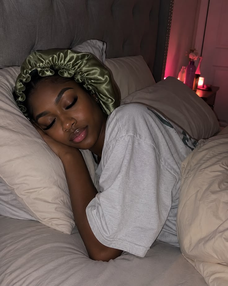Woman protecting transitioning hair with a satin bonnet at night