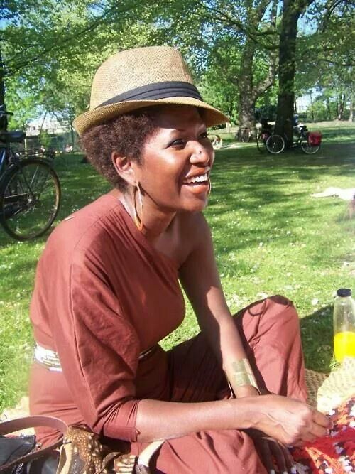 Woman wearing a wide-brimmed hat with natural 4C hair outdoors