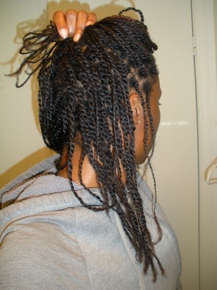 Woman wearing a low-tension protective style during a natural hair transition