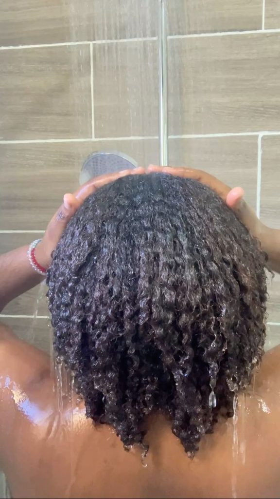 Natural 4C hair being rinsed after a rice water treatment