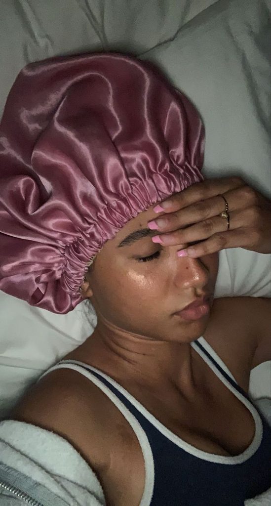 Woman wearing a satin bonnet to protect natural hair at night