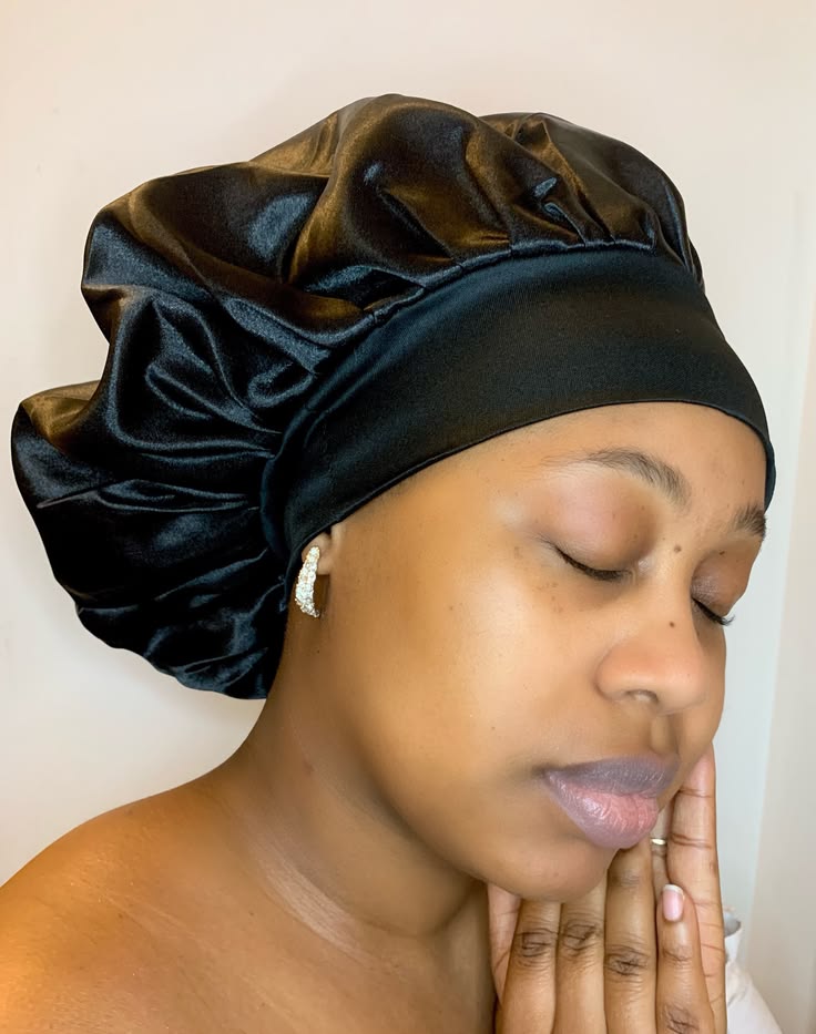 Black woman wearing a satin bonnet to protect transitioning hair while sleeping