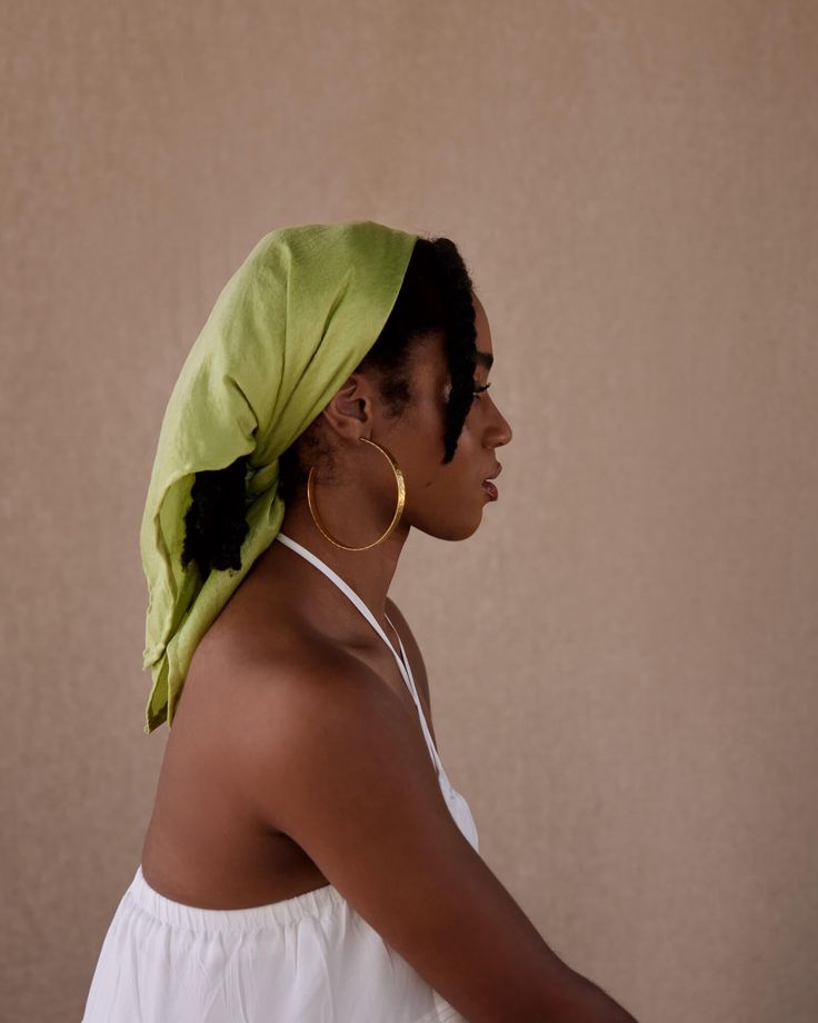 Woman styling natural hair with a satin scarf
