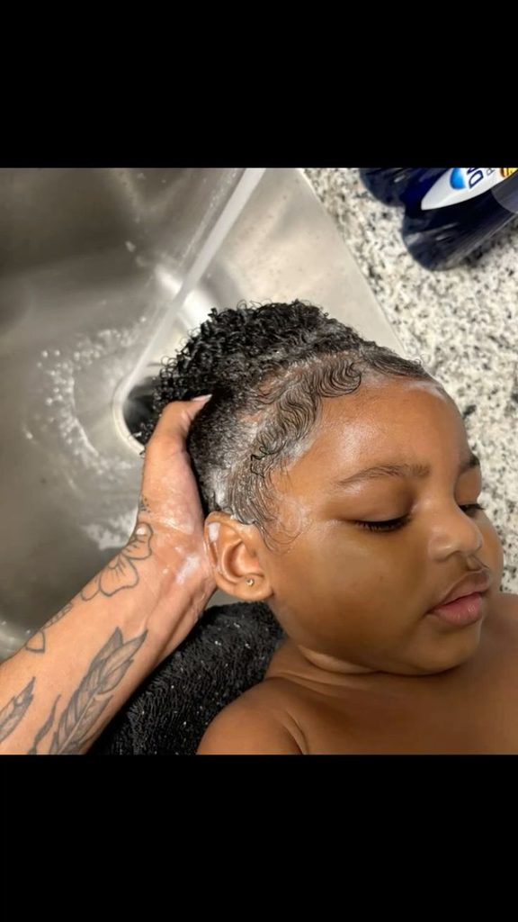 Parent gently shampooing a child's 4C hair and scalp