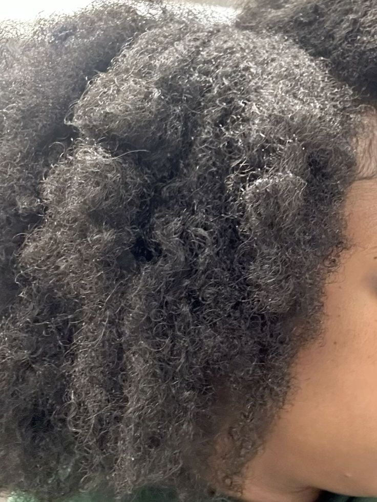 Woman checking dry natural 4C hair during winter