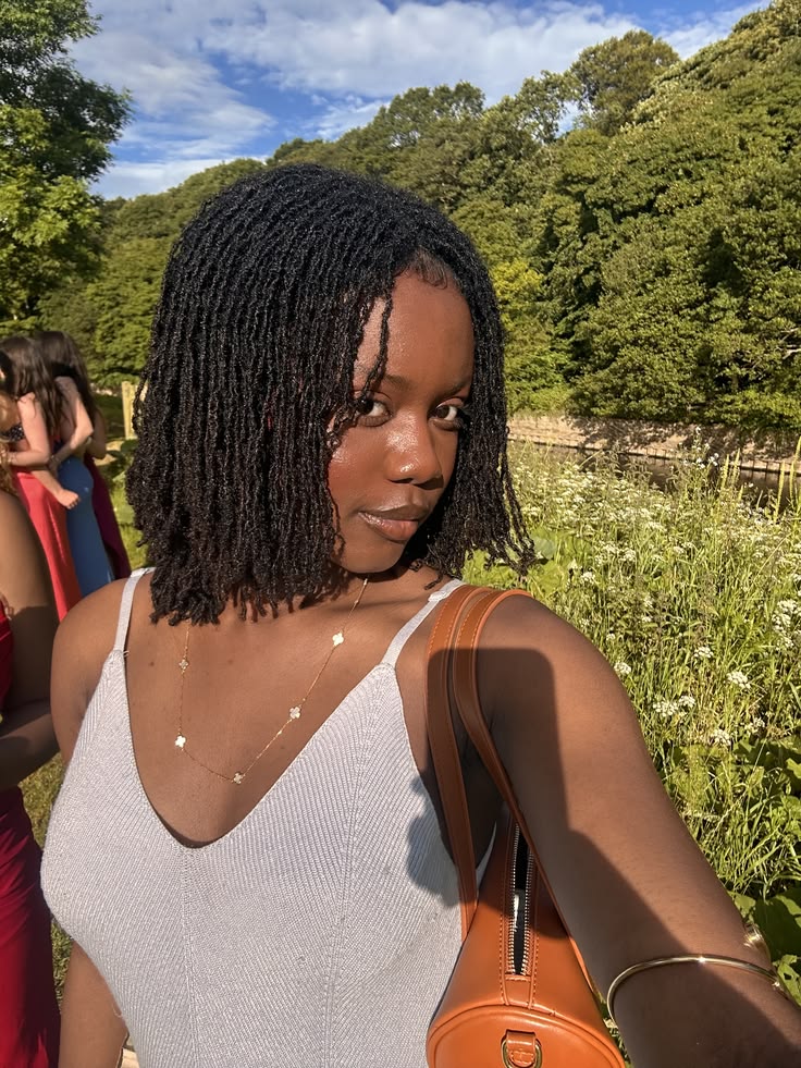 Woman wearing small Sisterlocks with natural hair styling