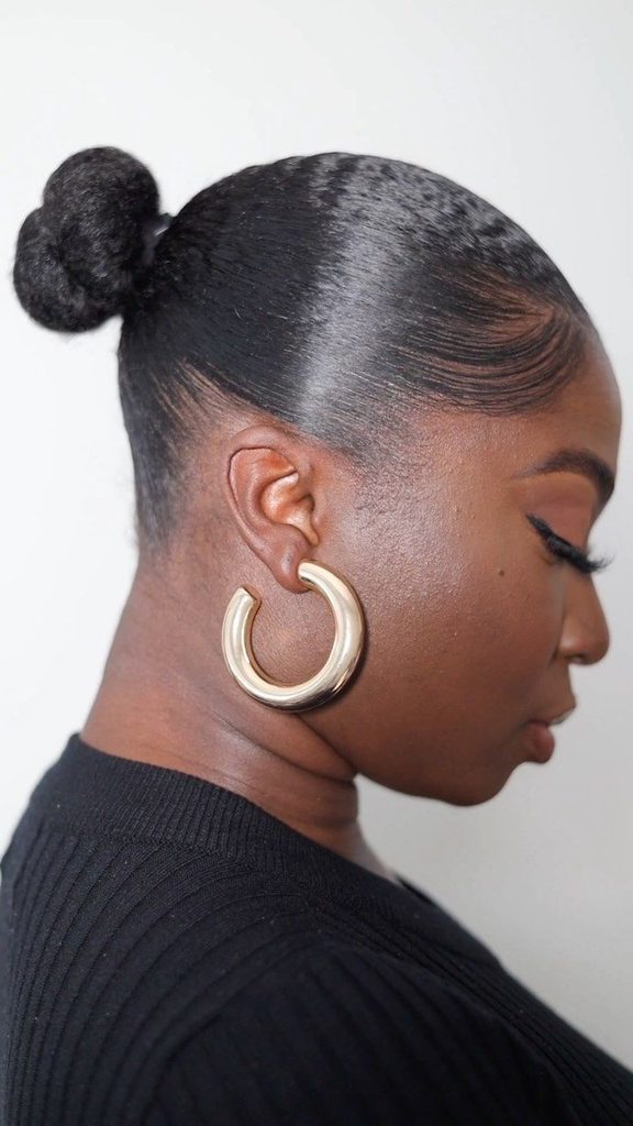 Woman wearing a sleek low bun with natural hair