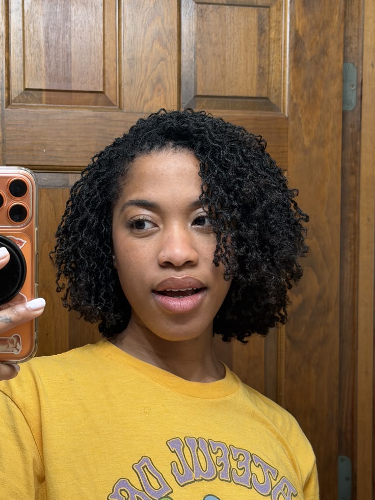 Small microlocs covering the head of a woman with tightly coiled natural hair