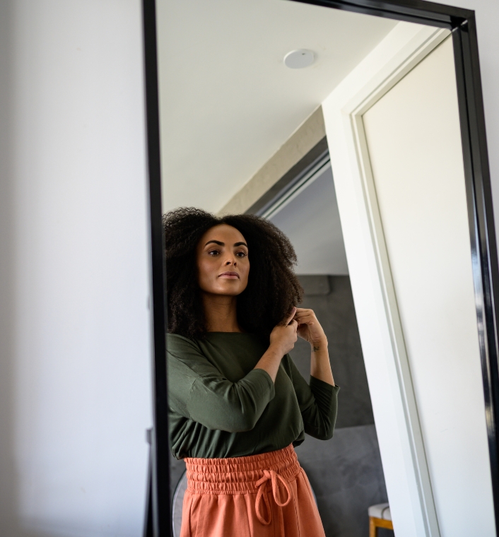 Woman examining her natural 4C hair in spring