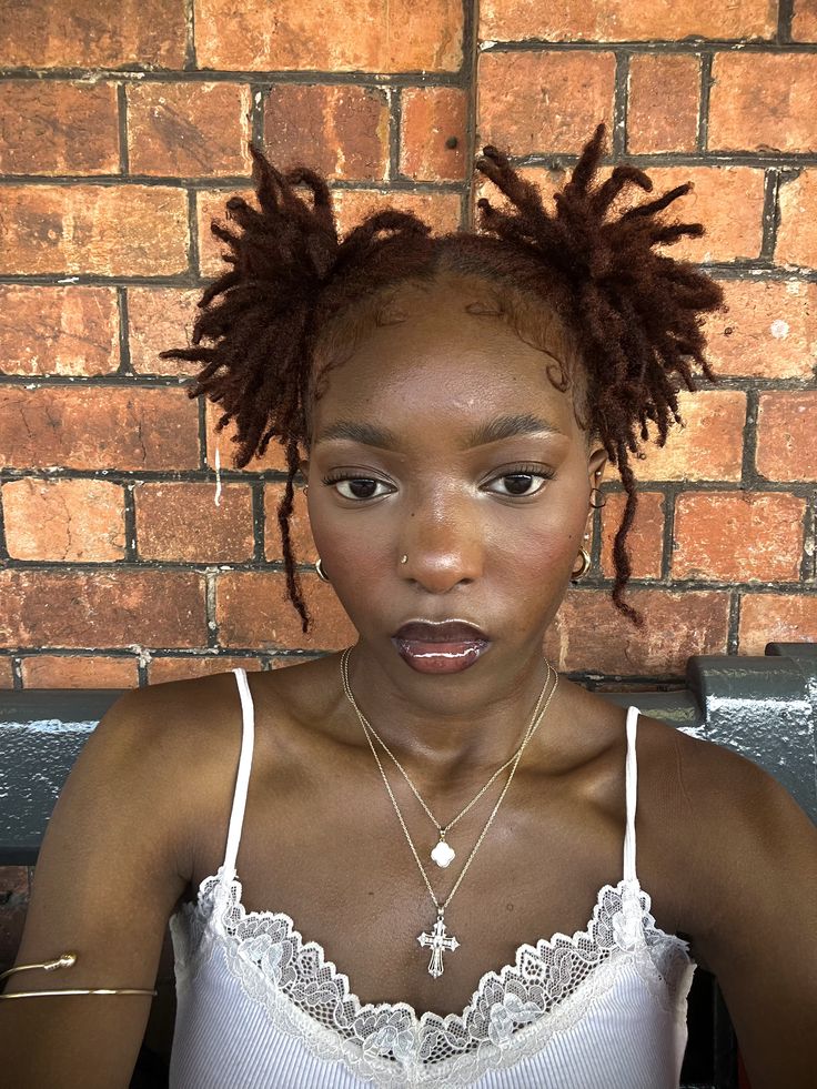 Young starter locs styled into two loose pigtails