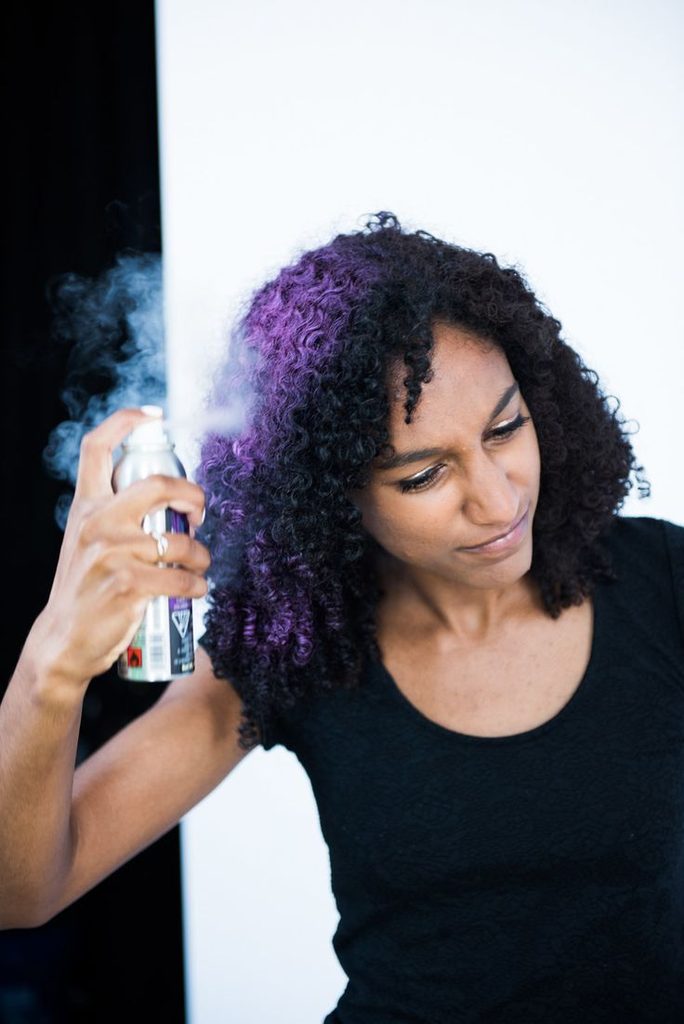 Black woman testing a temporary hair color before permanent coloring