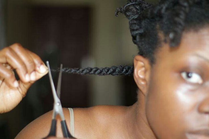 Woman trimming the relaxed ends of transitioning hair