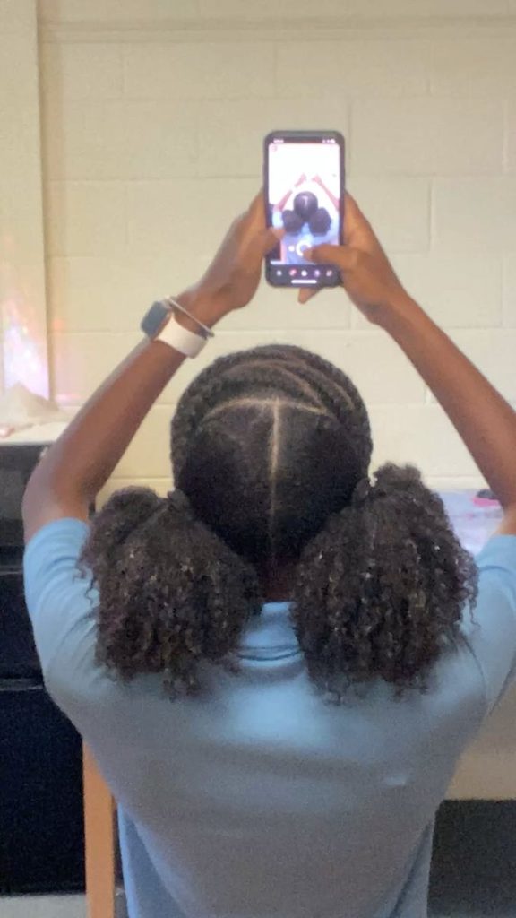 Woman wearing two low puff hairstyles on natural 4C hair