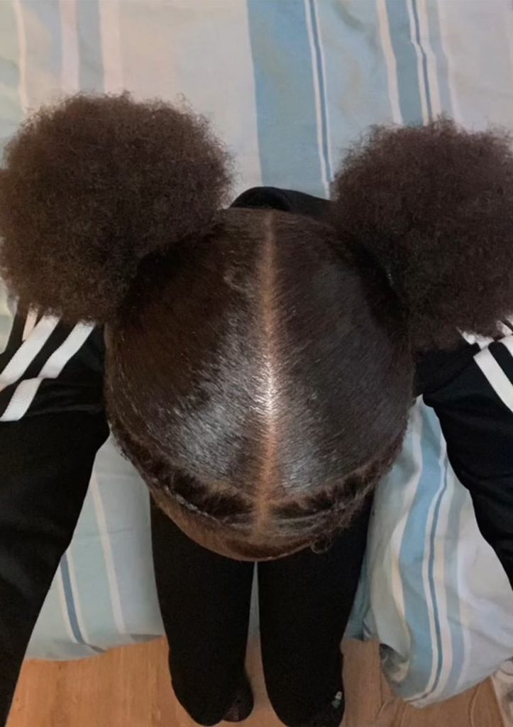 Woman wearing two low puffs on natural hair for rainy day