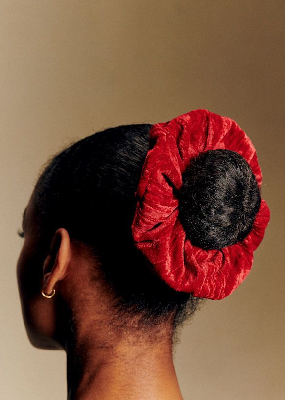 Woman wearing a velvet scrunchie with natural hair