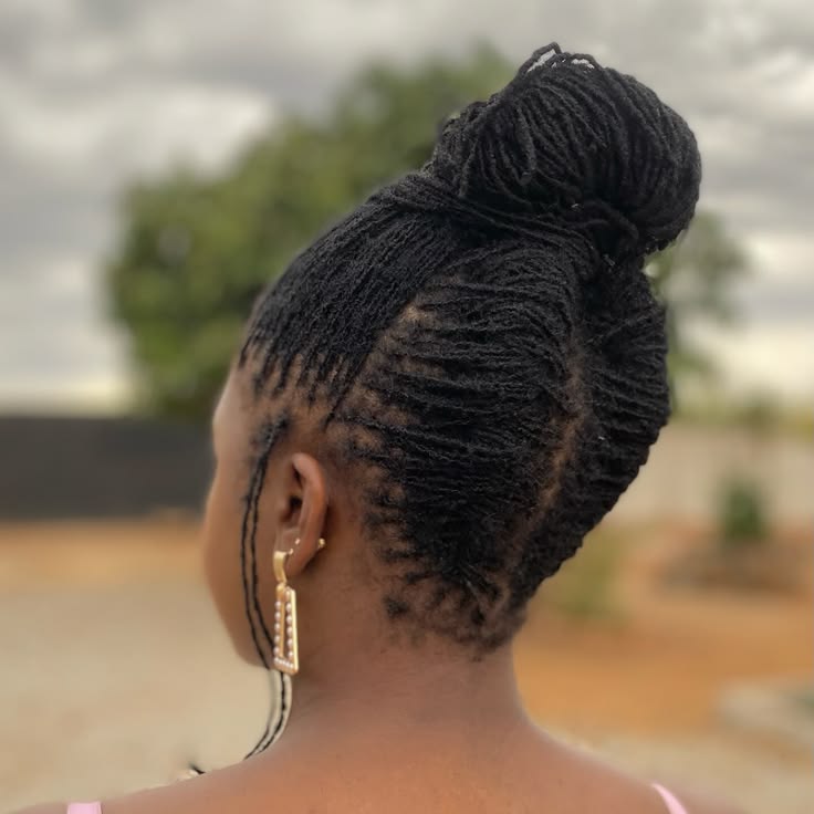 Woman wearing small locs in a versatile updo hairstyle