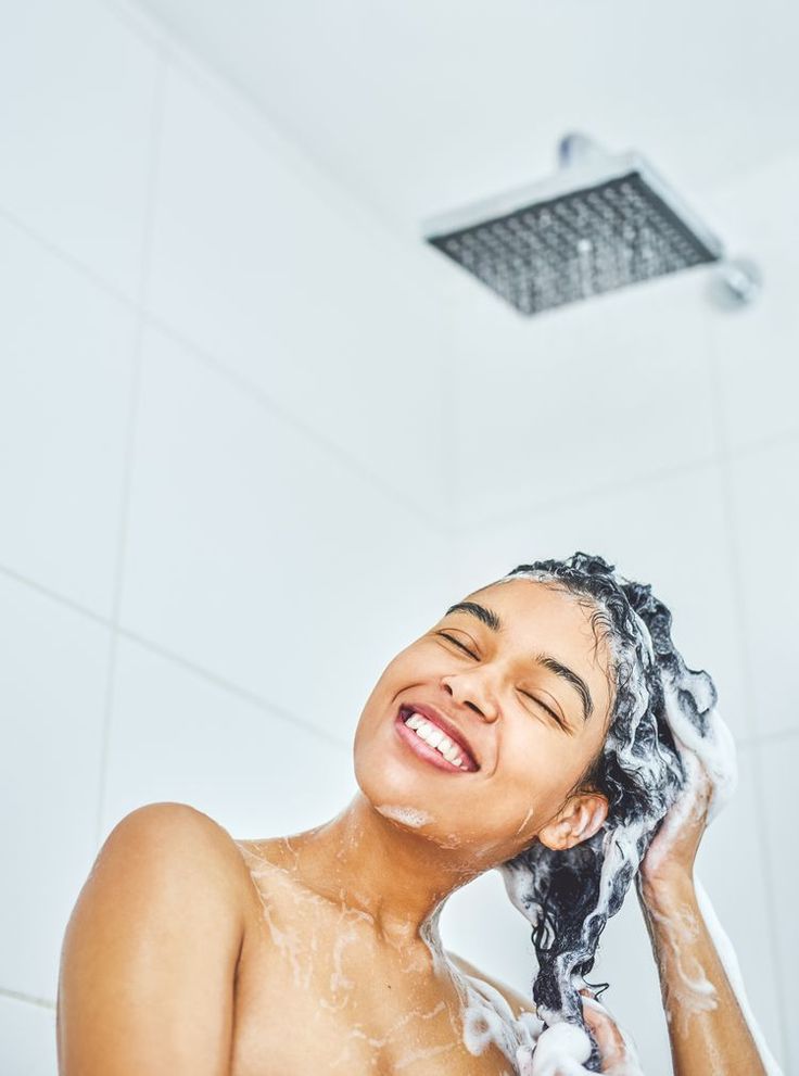 Woman cleansing natural 4C hair during a summer wash day