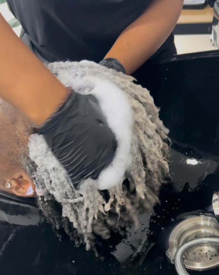 Woman washing microlocs while caring for her scalp