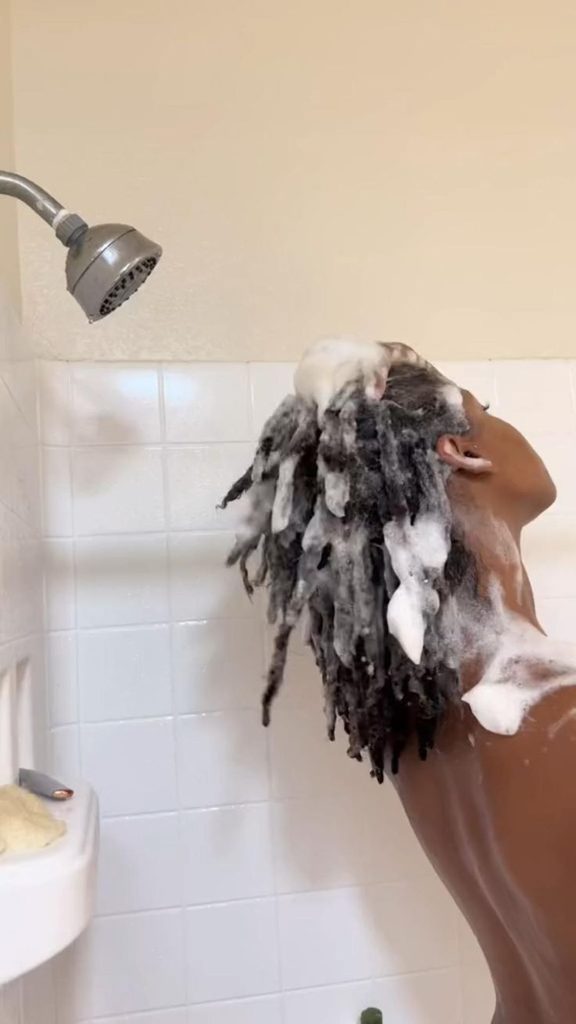 Woman gently washing natural locs during wash day
