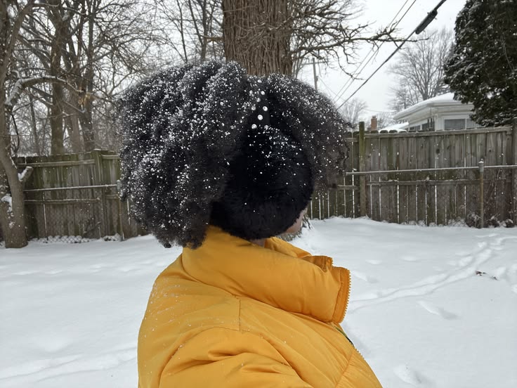 Close-up lifestyle photo of a Black woman with healthy, 4C hair during a winter season